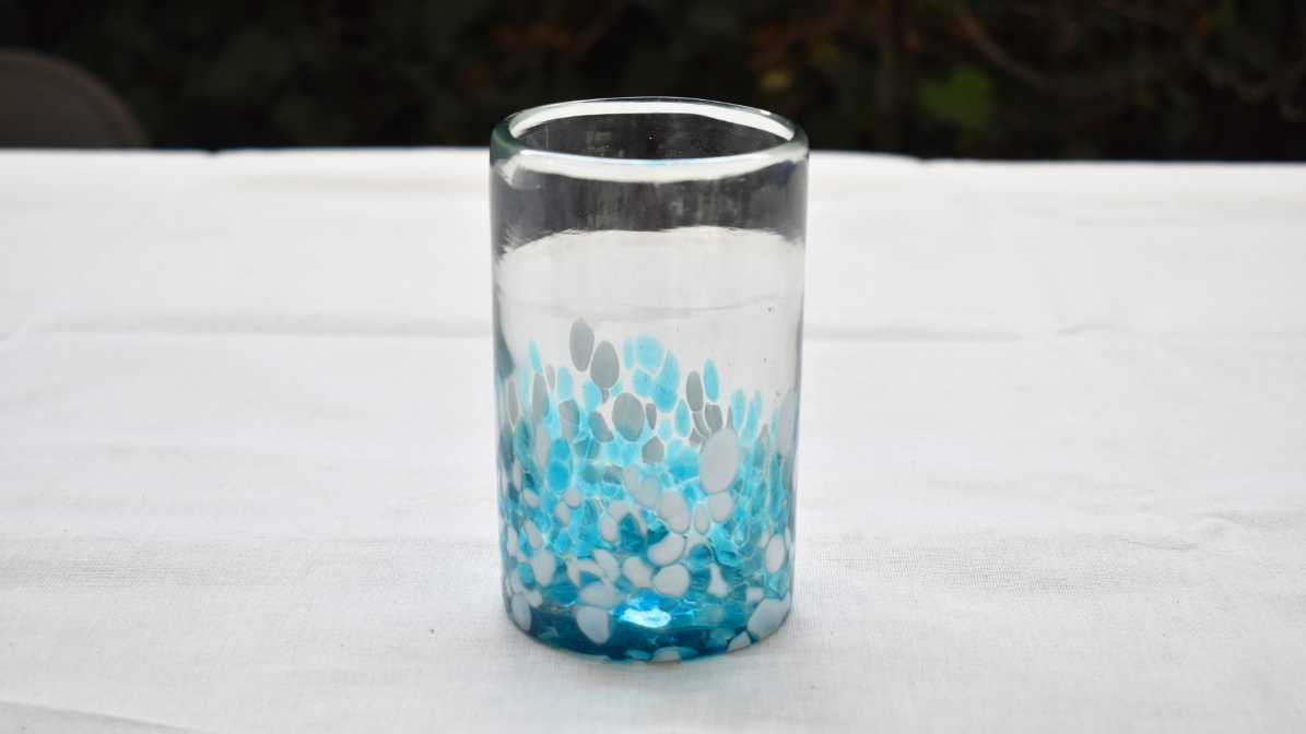Vaso de vidrio soplado con pintas color aguamarina y blanco a la mitad del vaso